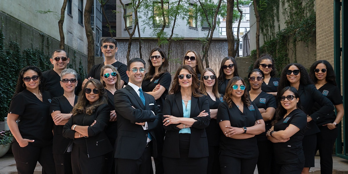 entire team posing with sunglasses on